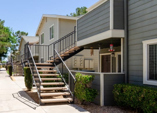 an exterior view of a gray house with stairs at Aspire High Desert Apartments, California, 92392