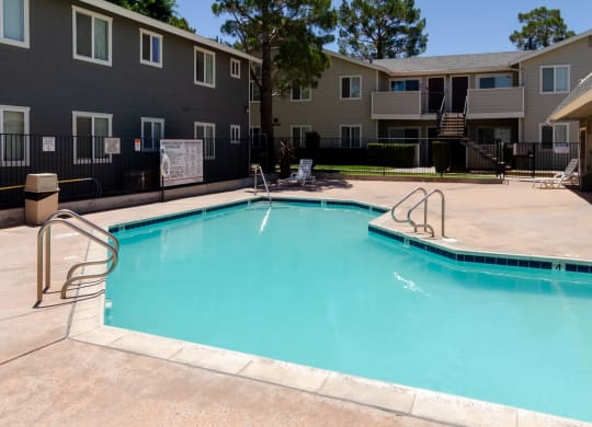 our apartments have a swimming pool with a fence and apartment buildings at Aspire High Desert Apartments, Victorville, CA, 92392
