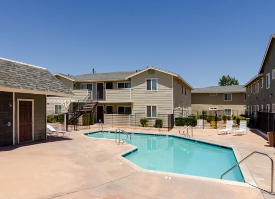 our apartments have a swimming pool with a building in the background at Aspire High Desert Apartments, Victorville