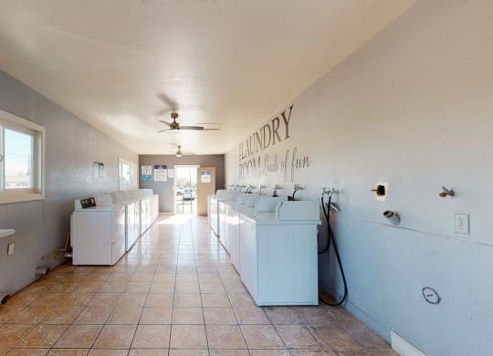 Laundry Room with Washing Machines, Dryers, and A Folding Station at Las Brisas Apartments, Colton, CA