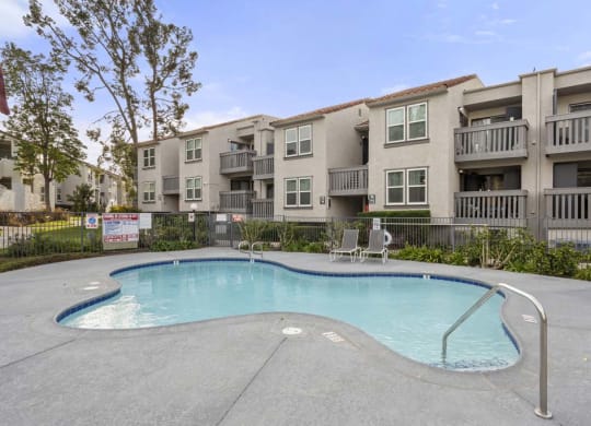 a swimming pool in front of an apartment building at Aspire Corona, Corona California