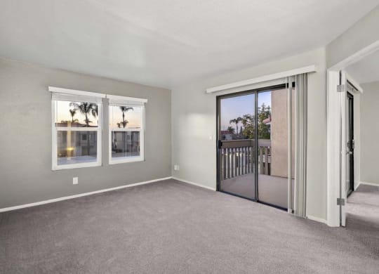 a bedroom with a sliding glass door and a balcony at Aspire Corona, Corona California