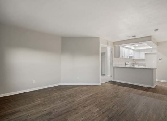 an empty living room with a kitchen in the background at Aspire Corona, Corona, 92882
