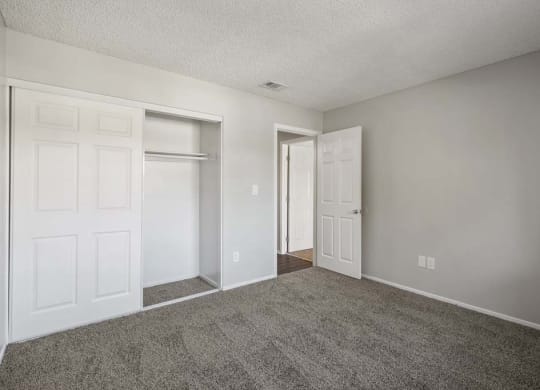 a bedroom with two doors and a carpeted floor at Aspire Redlands, Redlands, 92374