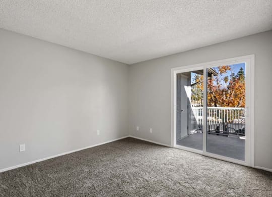 a bedroom with a sliding glass door and a balcony at Aspire Redlands, Redlands California