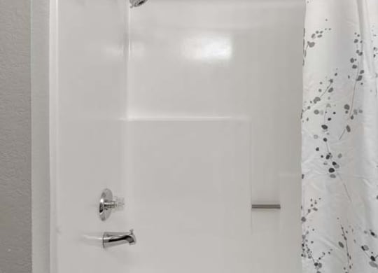 a white bath tub sitting next to a shower curtain at Aspire Redlands, California, 92374