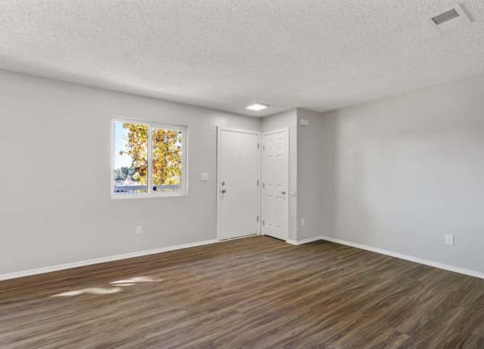 an empty bedroom with hardwood floors and a door to the bathroom at Aspire Redlands, Redlands, 92374