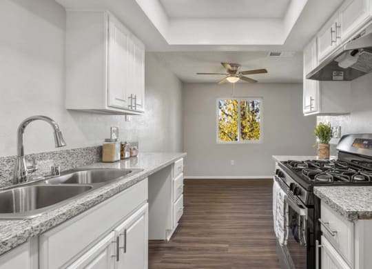 a kitchen with a stove top oven next to a sink at Aspire Redlands, Redlands California
