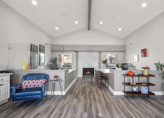 a living room with a fireplace and a blue chair at Aspire Redlands, Redlands, CA