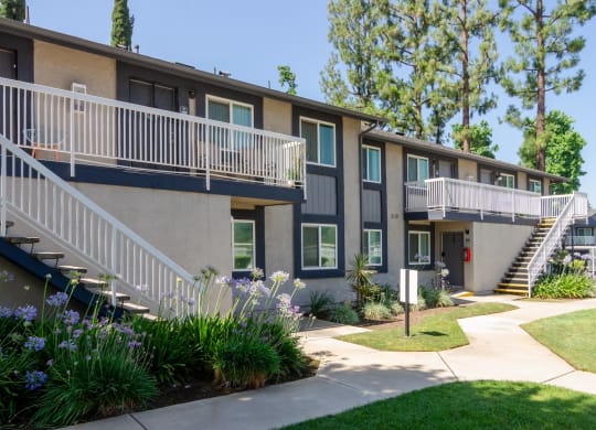 an exterior view of a building with stairs and a yard with flowers at Aspire Redlands, California, 92374
