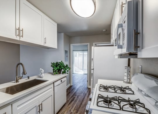 a kitchen with white cabinets and a sink and a stove at Aspire Seneca, Victorville