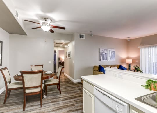 an open kitchen and dining area with a dining table and chairs and a living room at Riverton of the High Desert Apartments, California