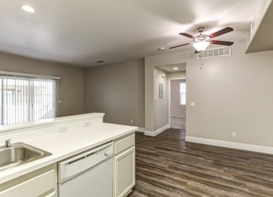 the kitchen and living room in a new home with a ceiling fan at Riverton of the High Desert Apartments, California, 92392