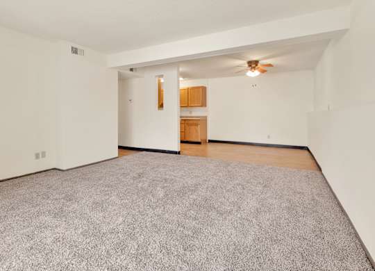 A room with a grey carpet and a ceiling fan. at Winding Hills Apartments, Davenport , IA, 52807