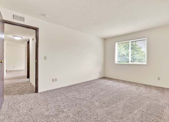 A room with a carpeted floor and a window. at Winding Hills Apartments, Davenport , IA, 52807