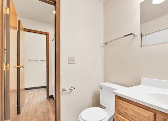 A white toilet sits in a bathroom next to a sink. at Winding Hills Apartments, Iowa, 52807