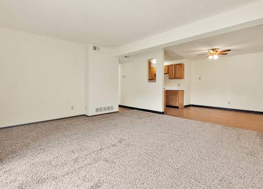 A room with a carpeted floor and a ceiling fan. at Winding Hills Apartments, Iowa
