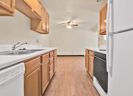 A kitchen with wooden cabinets and white appliances. at Winding Hills Apartments, Davenport  52807