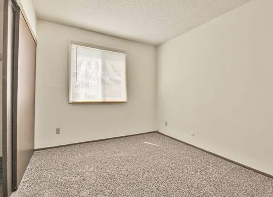 A room with a window and a picture frame on the wall. at Winding Hills Apartments, Iowa, 52807