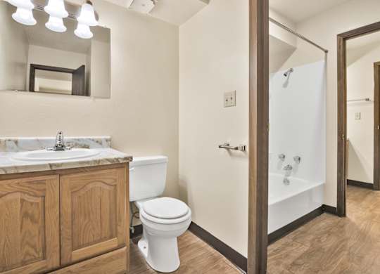 A bathroom with a toilet, sink, and mirror. at Winding Hills Apartments, Davenport , Iowa