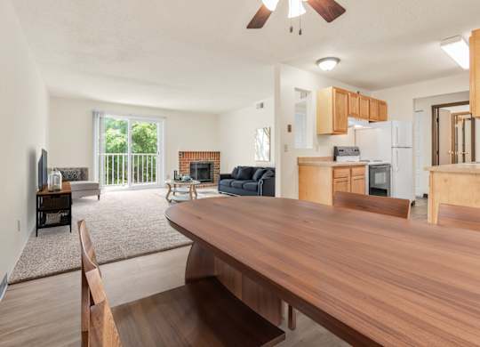 A modern kitchen with wooden cabinets and a dining table. at Winding Hills Apartments, Davenport