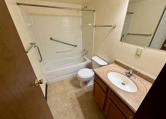 A bathroom with a toilet, sink, and bathtub. at Winding Hills Apartments, Iowa, 52807