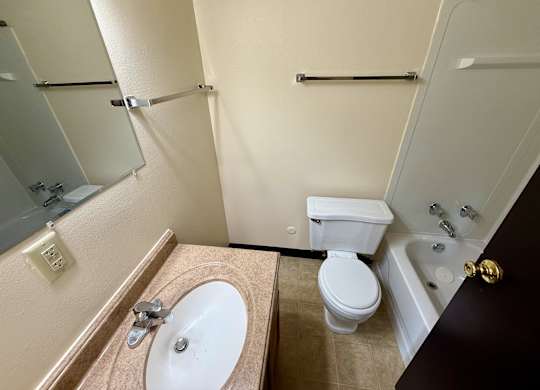 A bathroom with a toilet, sink, and bathtub. at Winding Hills Apartments, Davenport  52807