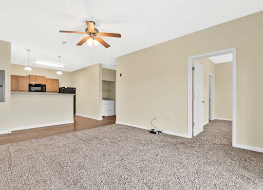 A room with a ceiling fan and a carpeted floor. at Deer Valley Apartments, Silvis
