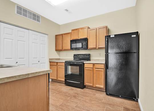 A kitchen with a black refrigerator, oven, and microwave. at Deer Valley Apartments, Illinois, 61282