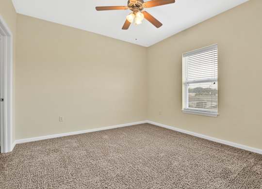 A room with a ceiling fan and a window with blinds. at Deer Valley Apartments, Silvis, Illinois