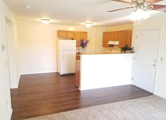 A kitchen with a white refrigerator and wooden cabinets.at Windsor Crest Apartments, Davenport