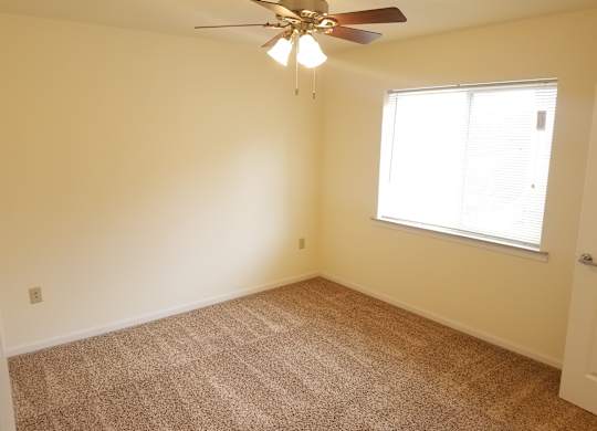 A room with a ceiling fan and carpeted floor.at Windsor Crest Apartments, Davenport