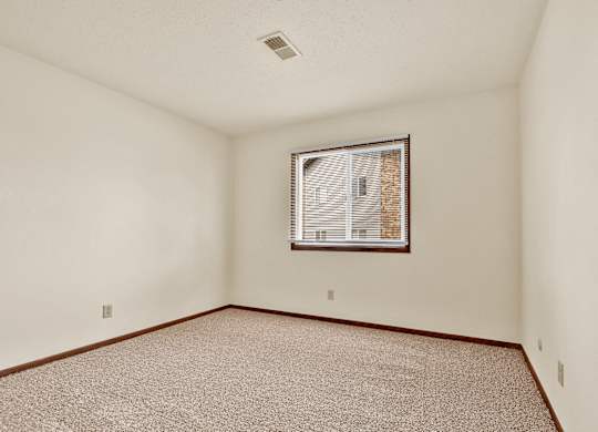 A room with a window and carpeted floor.at Windsor Crest Apartments, Davenport