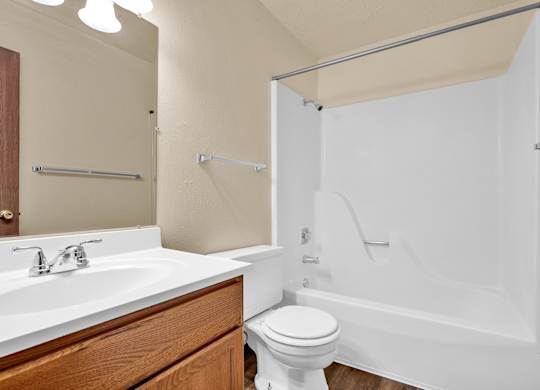 A white toilet sits next to a white sink in a bathroom.at Windsor Crest Apartments, Davenport
