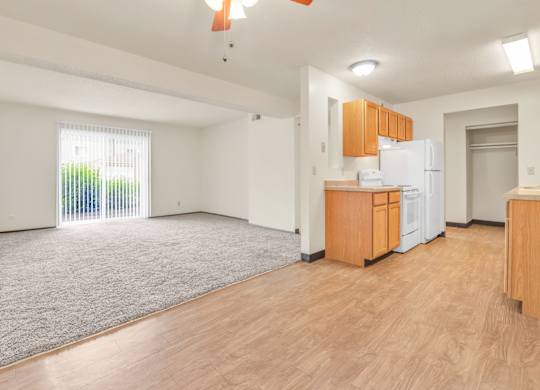 A room with a kitchenette and a sliding glass door leading to a balcony. at Winding Hills Apartments, Davenport, Iowa