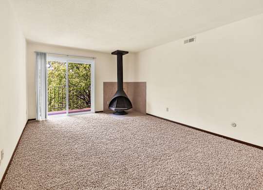A room with a carpet floor and a fireplace. at Indian Ridge Apartments, Davenport, Iowa