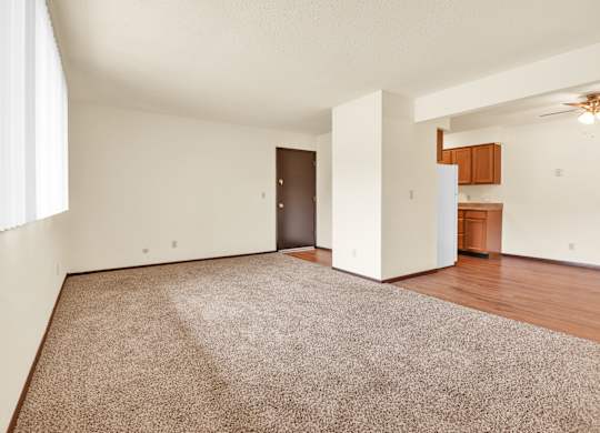 A room with a brown carpet and a ceiling fan. at Indian Ridge Apartments, Davenport