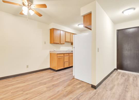 A kitchen with wooden floors and a ceiling fan. at Indian Ridge Apartments, Davenport
