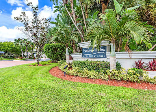A sign for Waterfront Park is surrounded by greenery.