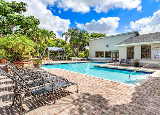 A pool with a black metal bench next to it.