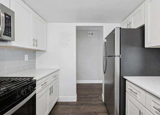 A kitchen with white cabinets and a black stove top oven.