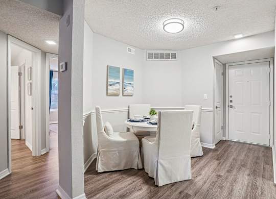 A dining room with a table and chairs.