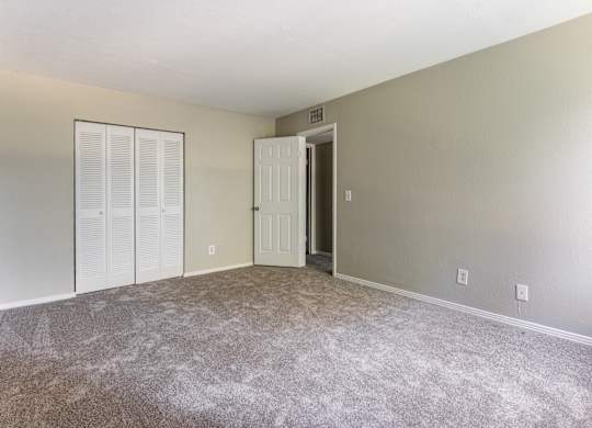 A room with a carpeted floor and a white door.