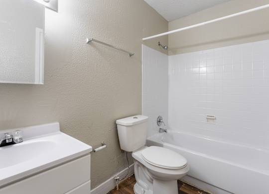 A white toilet sits next to a white sink in a small bathroom.