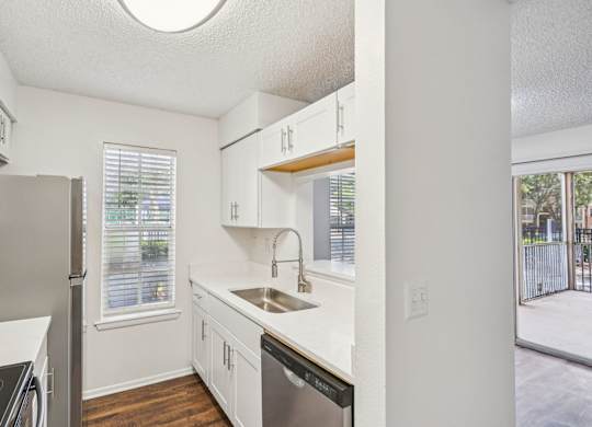 A kitchen with white cabinets and a black stove top oven.
