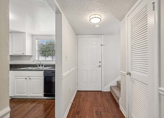 A white door is at the end of a hallway.
