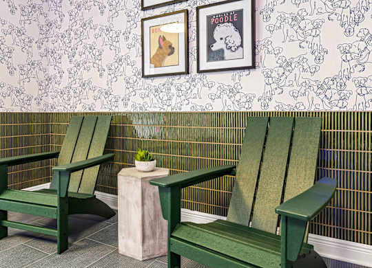 Two green chairs and a small table with a plant on it.