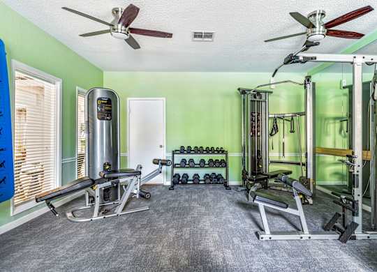 A home gym with a variety of equipment including weights and machines.