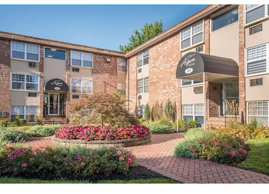 A brick building with a flower bed in front.