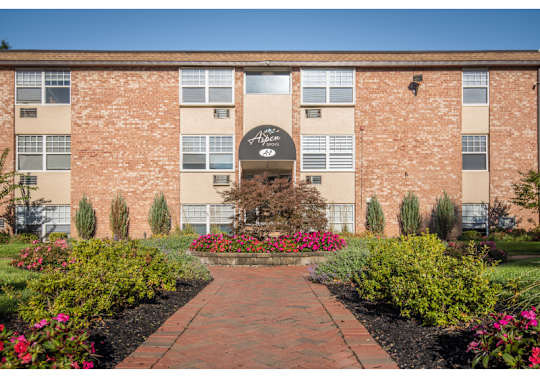 A brick building with a garden in front.